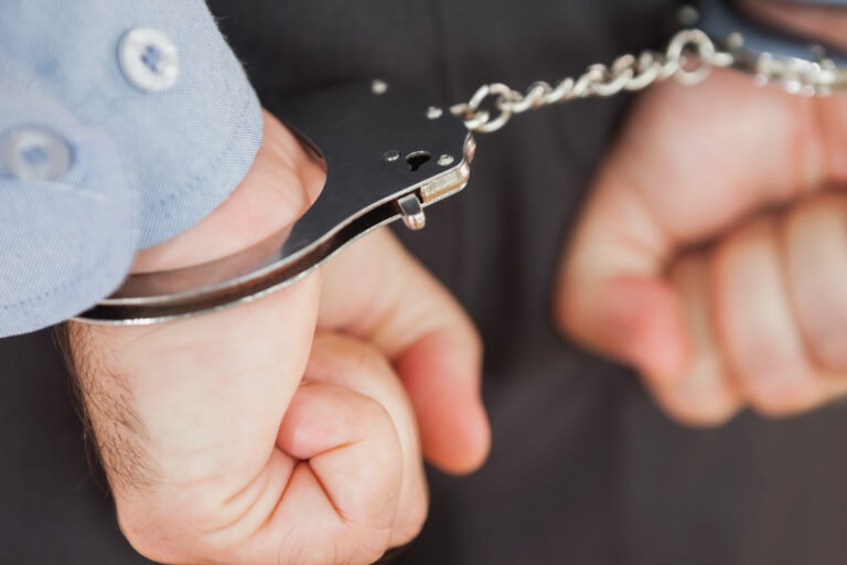 Closeup of hands with handcuffs while clenching fists