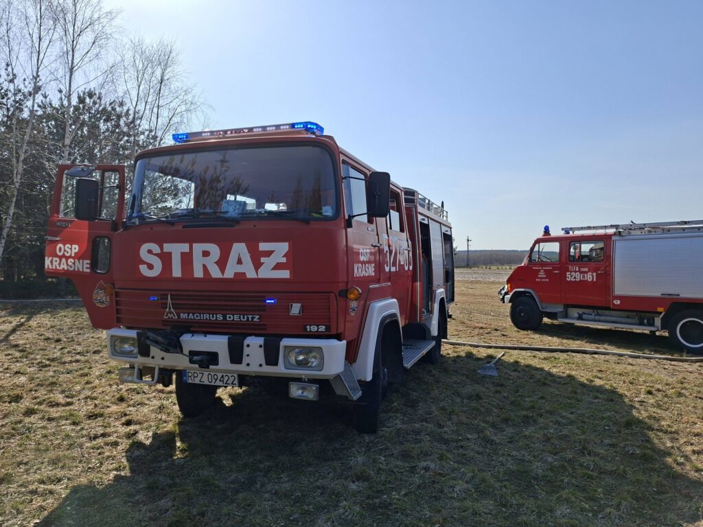 Samochody straży pożarnej podczas działań przy pożarze traw i młodnika w miejscowości Majdan Sieniawski.
