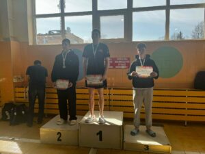 Szymon Pelc na podium podczas zawodów pływackich na basenie w Krośnie